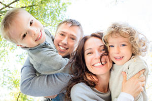 A mother and Father is holding their children.