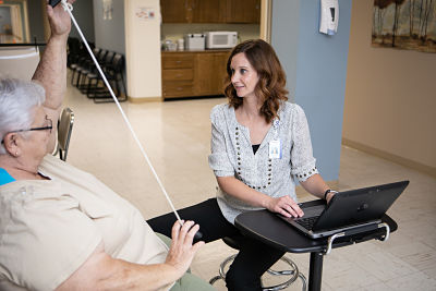 a Physical therapist is helping a patient with physical therapy